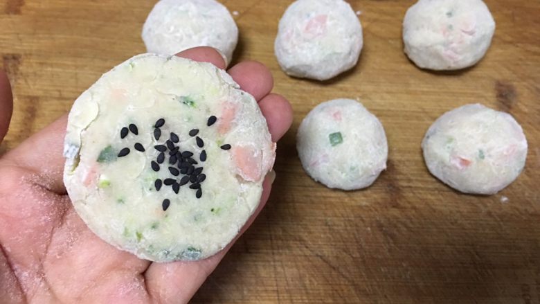 便当~饭团+土豆饼+八爪鱼红肠,取适量搓圆,沾手的话,可以滚一圈干粉更易操作哦,压扁,撒上点黑芝麻装饰,同时也增加风味