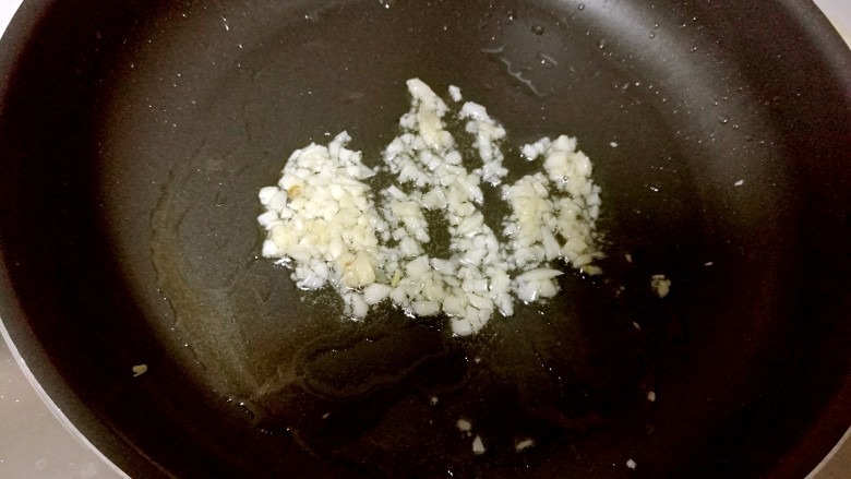 豆角烧茄子,锅中放油烧热,放入蒜未炒出香味。