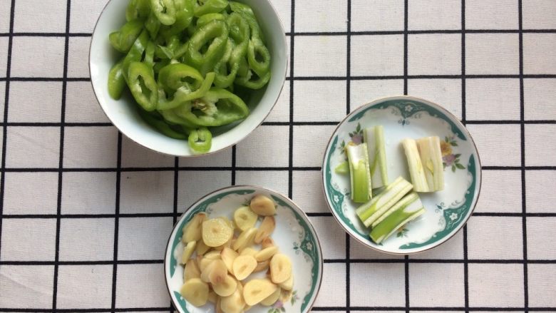 【下饭菜】爆炒猪心,将尖椒切丝,大蒜切片,葱切段。