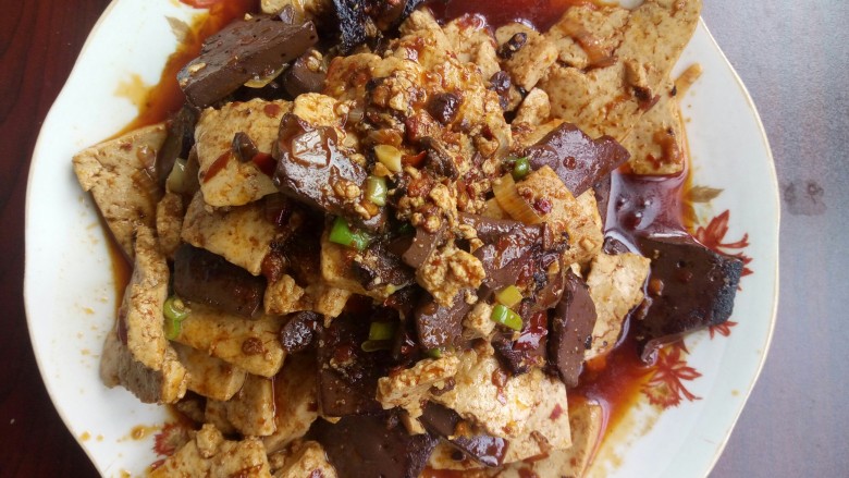 猪血烧豆腐,上锅热油,加入辣椒、<a style='color:red;display:inline-block;' href='/shicai/ 700'>花椒</a>、蒜末煸炒出味,放入豆腐猪血翻炒几下,加入适量料酒,老抽一勺,加适量清水大火烧开,小火收汁,放入盐和味精,撒葱花出锅。👌我不会摆盘,卖相不好请见谅