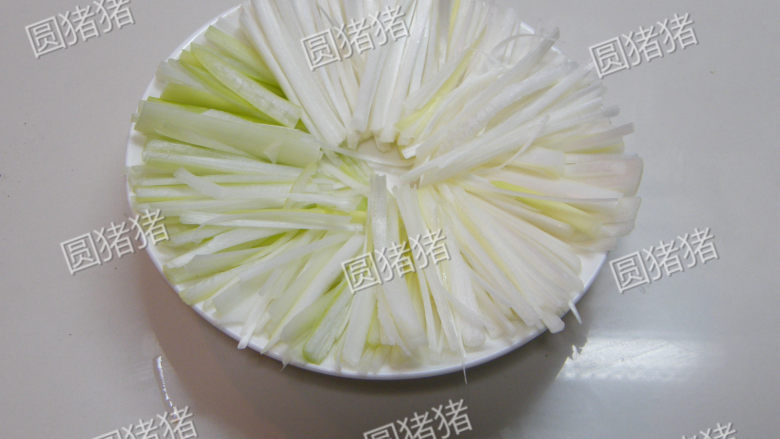 京酱肉丝做法,将京葱白切成细切状,摆放在盘底,上面盛装肉丝即可。吃的时侯包上豆皮或春饼皮。