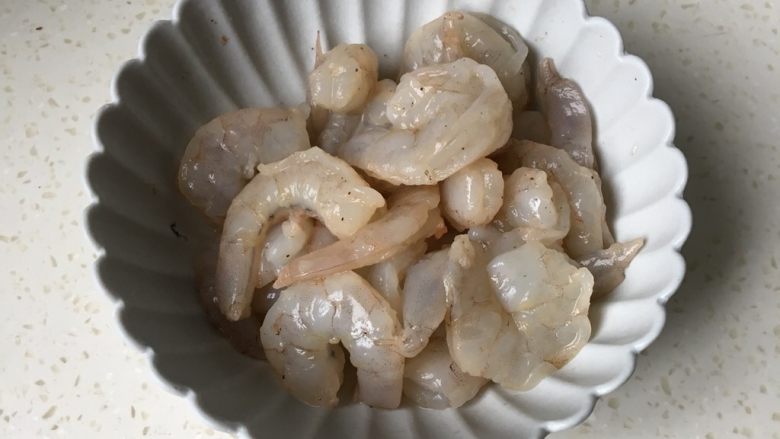 莴笋虾仁,倒掉腌制的水,放入二克盐和淀粉戴上一次性手套,把虾仁抓均匀备用