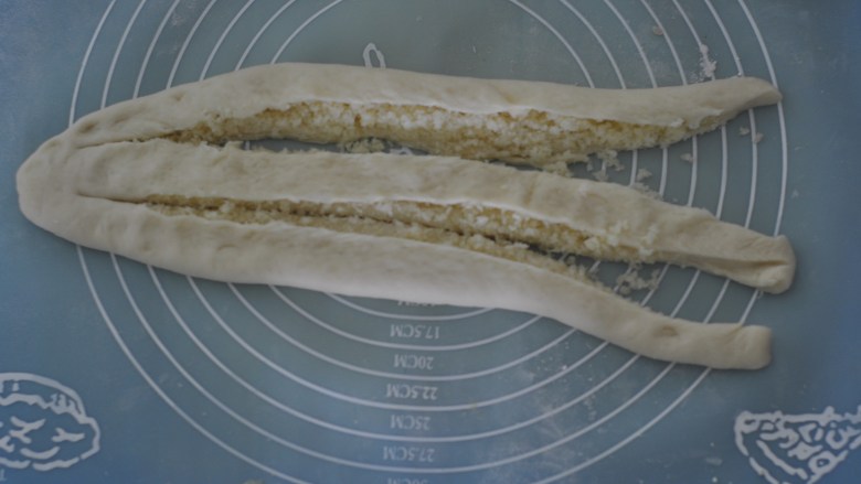 椰蓉面包卷,用刀纵切为3份，上面不切断