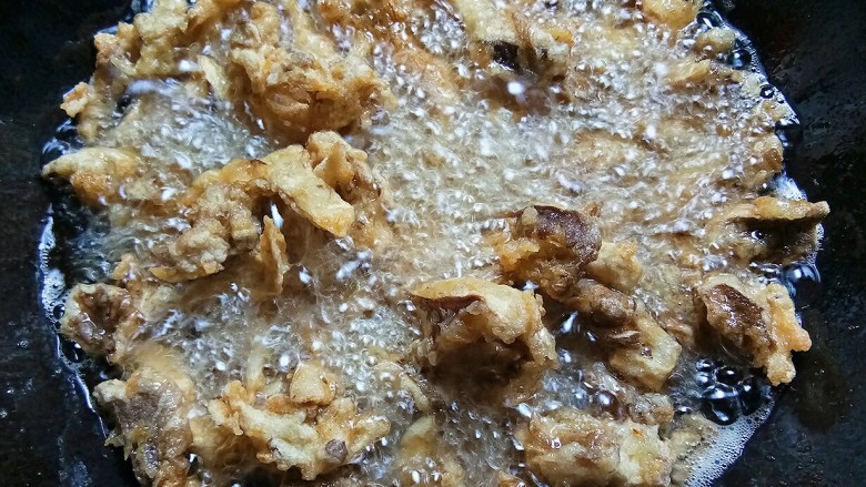 脆炸蘑菇,然后转大火,烧热油进行复炸,看到气泡变小就捞出控油盛盘即可