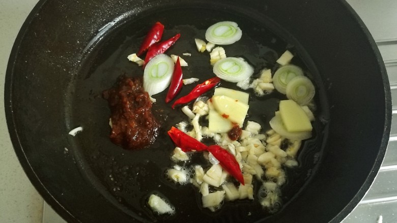 辣烧带鱼,锅中放少许底油,放入葱姜蒜,干辣椒,豆瓣酱翻炒。