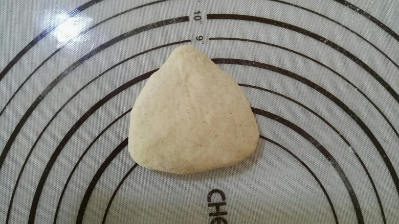 好看又好吃的——褐麦红豆沙三角包,取出一个小面团,用手整理成三角形,再用手掌压扁,这个初始的三角形可是关键哦,这个步骤不能少。