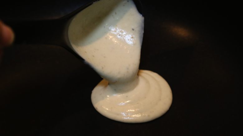 香蕉松饼,不粘锅锅烧热,舀一勺面糊放入锅中,滴落成圆形。