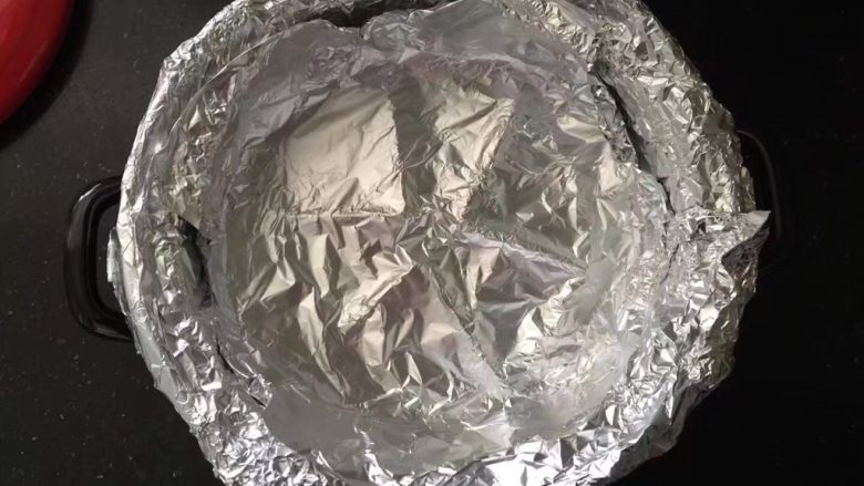 砂锅烤红薯,裁剪2张足够大的锡纸,以十字交叠的方式贴紧砂锅内壁和砂锅顶部边缘.