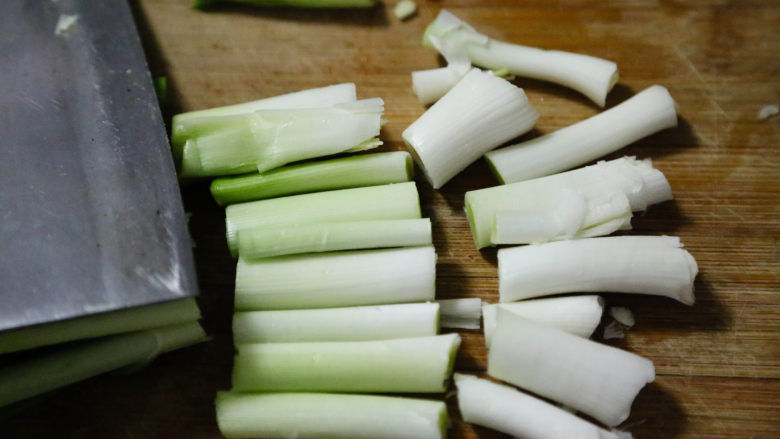 农家腊肠炝蒜,蒜白用刀拍松后,切成段。