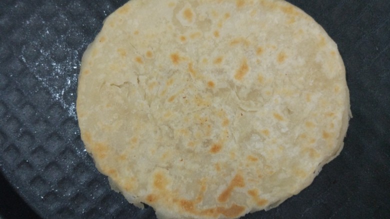 家常烙饼,电饼铛预热下盘,锅底刷一层油,放入饼胚,不需要油多,油多表层容易硬。烙一会儿,顶层刷薄薄一层油,同样不需要多,期间根据情况翻几次面。大约六分钟,两面金黄,饼鼓起就好了。