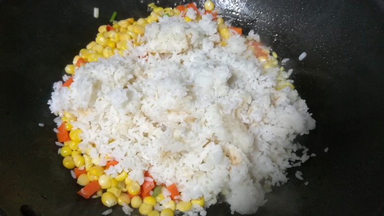 金灿灿的玉米炒饭,倒下剩饭翻炒后,马上加入刚刚准备好的调料,再继续翻炒几下就可以出锅了。