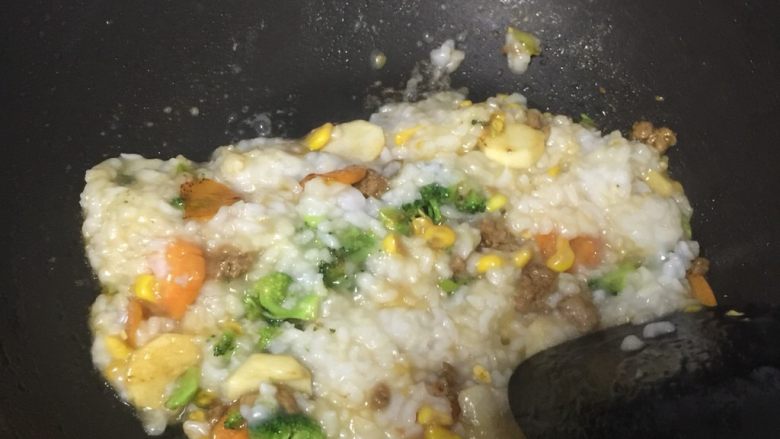 瘦肉玉米蔬菜粥,最后把稀饭倒入跟所有食材混合,翻炒下。