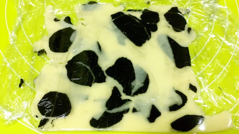 奶牛小饼干,剩下的边角可以叠在一起,再次擀成2毫米厚的片,用奶牛模具压出形状,剩下的混合一起,揉成浅黑色
