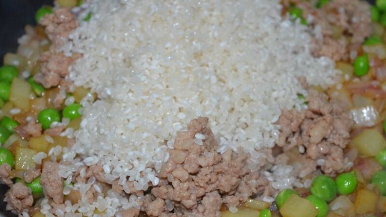 懒人美食之~肉末洋葱双豆焖饭,加入米,翻炒均匀
