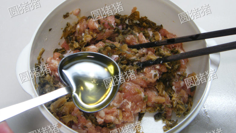 梅菜蒸猪肉,将梅干菜及沙拉油放入绞肉内,用筷子顺时针方向搅拌均匀。
