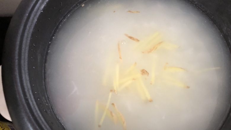香菇鸡肉粥,电饭锅加水煮开后倒入泡好的大米和姜丝煮开,开盖再煮二十分钟左右,煮至米粒开花。