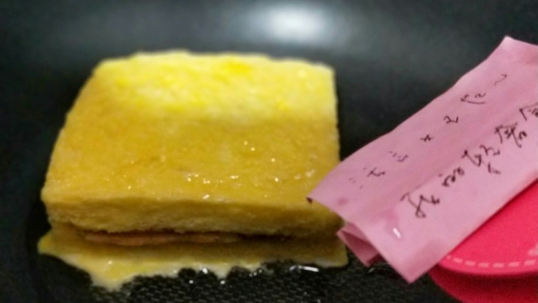 #辅食计划#芝士培根三明治,平底锅中刷少许食用油,放入沾满蛋液的吐司。