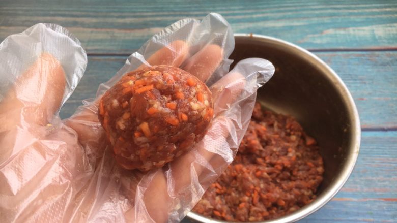 香煎黑胡椒胡萝卜牛肉饼,取55g左右的肉馅,团成圆球,压成肉饼。
