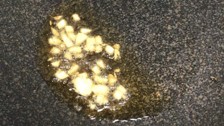 宝宝最爱 香菇排骨粥,稍微热锅后放芝麻油,待油温升高后放入蒜头煸香,颜色微微变金黄即可。