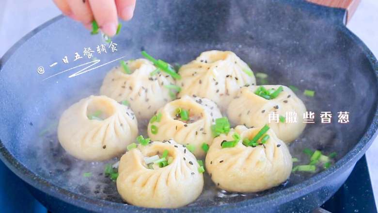 杂蔬鱼肉生煎包,焖4分钟,撒些黑芝麻和香葱,转小火焖煮至水收干。