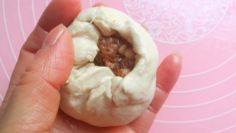 鲜香肉馅饼,从四周将面皮向中间捏,包起来,类似包包子的手法,将肉馅包入面团里。