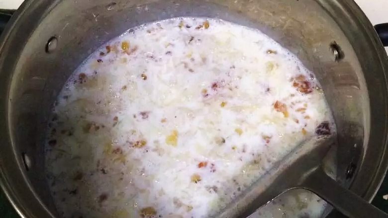 牛奶桃胶银耳羹,用锅铲拌匀,继续熬至待牛奶沸腾。