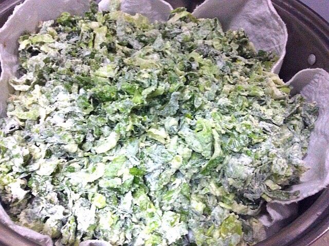 (两吃)莴笋叶蒸麦饭,锅中铺好龙布把拌好的莴笋叶子均匀的铺子龙布上盖上盖子,上汽后蒸8分钟关火