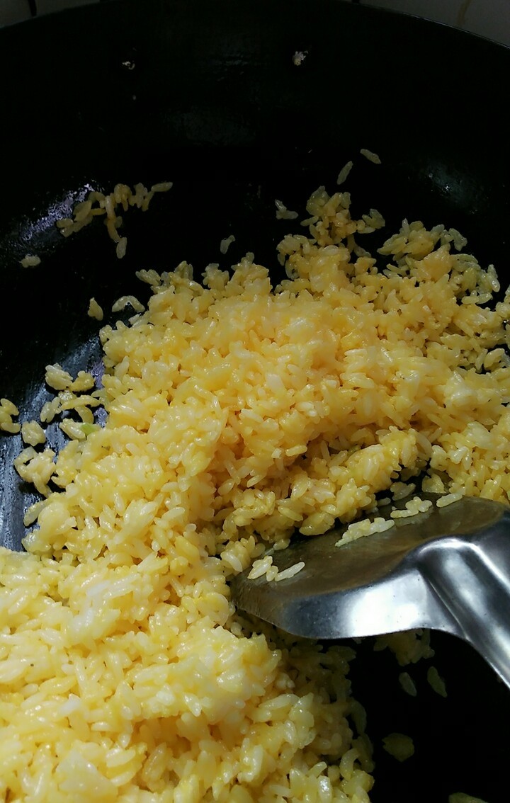 黄金炒饭,开始翻炒,就会呈现一粒粒黄金颗粒,不要加水,这样米饭没有炒起来好吃,加入<a style='color:red;display:inline-block;' href='/shicai/ 720'>胡椒粉</a>调调口味,还有盐,米饭多就得多加免得太淡