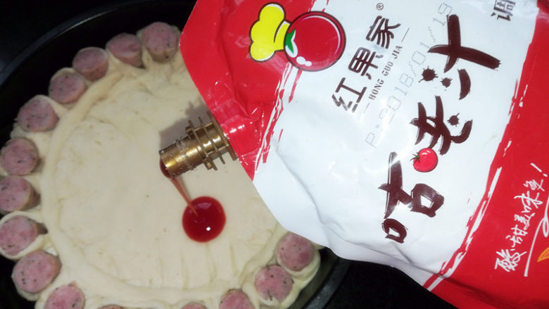 满园春色香肠披萨,在饼皮上用叉子戳一些小洞,倒上披萨酱或者番茄酱或者咕咾汁。