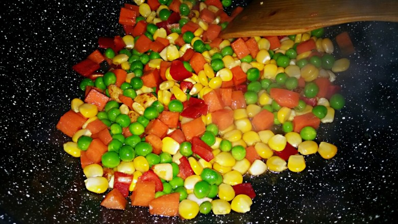 治愈菜~五彩丁盖饭,大火炒一两分钟后倒入豌豆和红辣椒,加入食用盐翻炒均匀,加少许水再盖上盖子焖上一两分钟