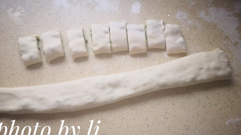 葱卷,将面团从上到下卷起来,然后用菜刀切成一小块一小块。
