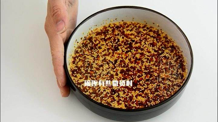 自己动手做辣椒油,好吃又卫生,碗还有些微烫的时候倒入一勺辣椒粉,搅拌均匀。