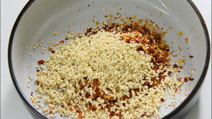 自己动手做辣椒油,好吃又卫生,2勺辣椒粉、1勺芝麻、半勺盐搅拌均匀。