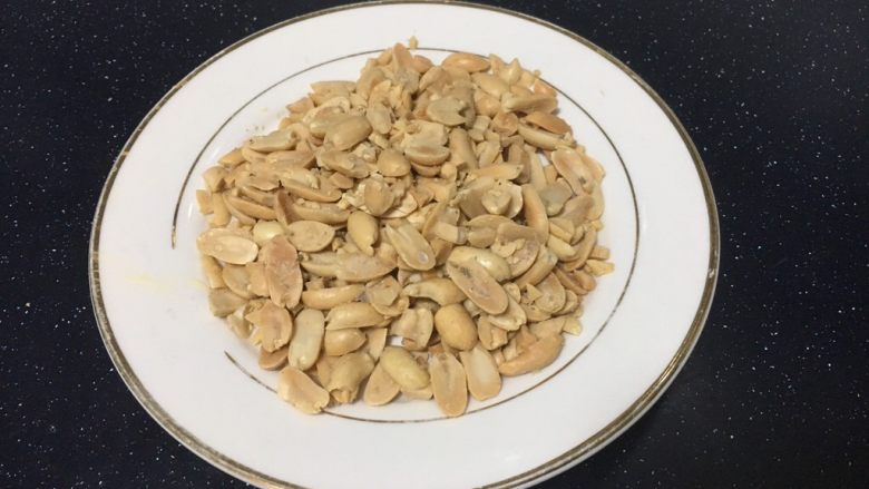 自制蔓越莓花生牛轧糖,准备果仁,将果仁皮去掉,放在保鲜膜里擀碎。