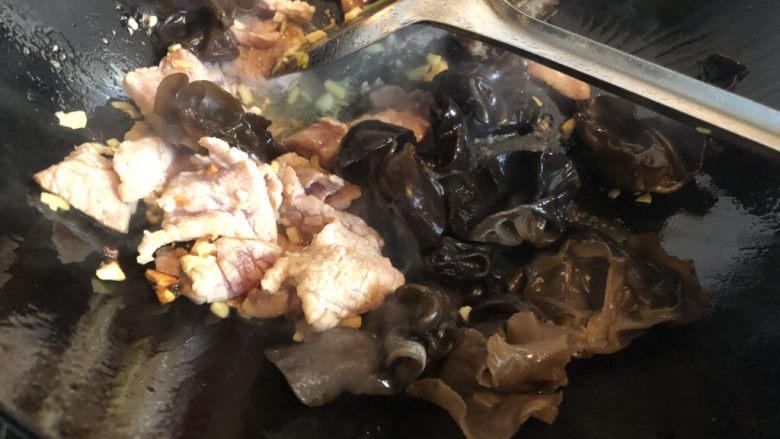 木耳香菜炒肉片,肉片变色后下木耳,翻炒。
