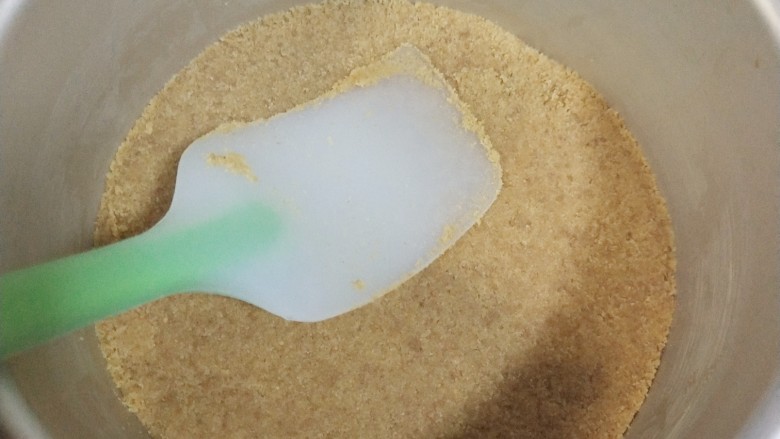 镜面芒果慕斯蛋糕,准备一个6寸的活底蛋糕模具,底部铺上油纸,把和无盐黄油拌好的饼干碎倒入模具,用刮刀压实,一定要压实,不压实脱膜的时候会散掉哦,然后放入冰箱冷藏一会