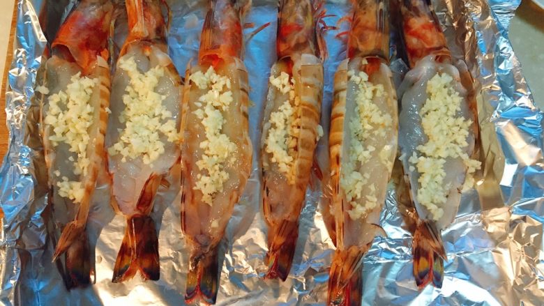 芝士焗大虾,大蒜切成蒜末,均匀放在虾背肉里