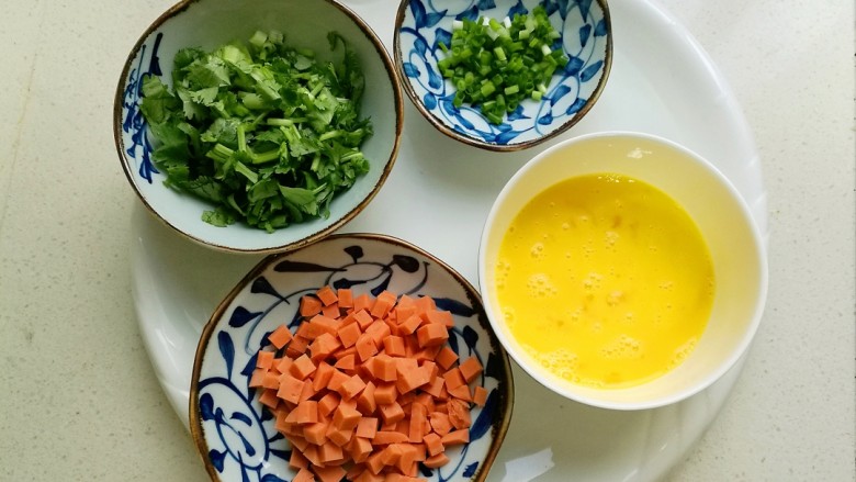 香菜蛋炒饭,鸡蛋打散,火腿肠切丁,香菜切小段,葱切成葱花备用。