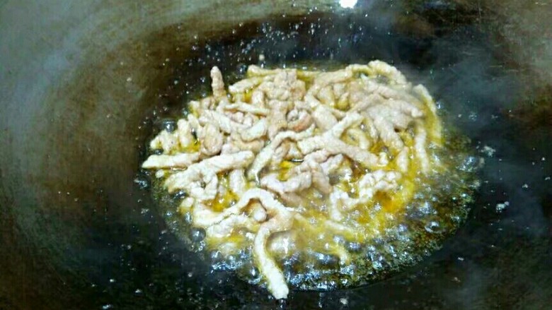 蒜苔肉丝,将肉丝炒散,炒到肉丝发白。