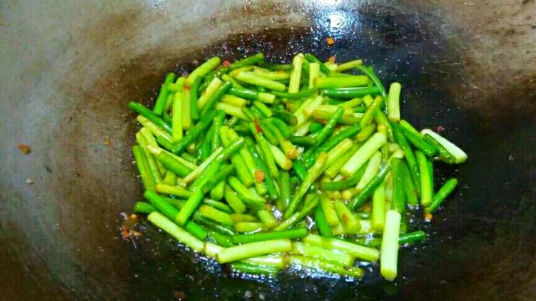 蒜苔肉丝,将盐翻炒均匀,炒到蒜苔快熟。