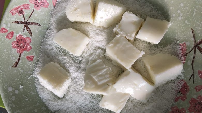 椰蓉奶冻,用手轻轻拿住奶冻翻面,让每一面都沾上椰蓉