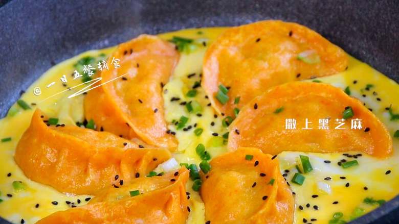 抱蛋煎饺,让蛋液铺满整个锅底,蛋液凝固后,撒上葱花和黑芝麻。这个过程1分钟吧。