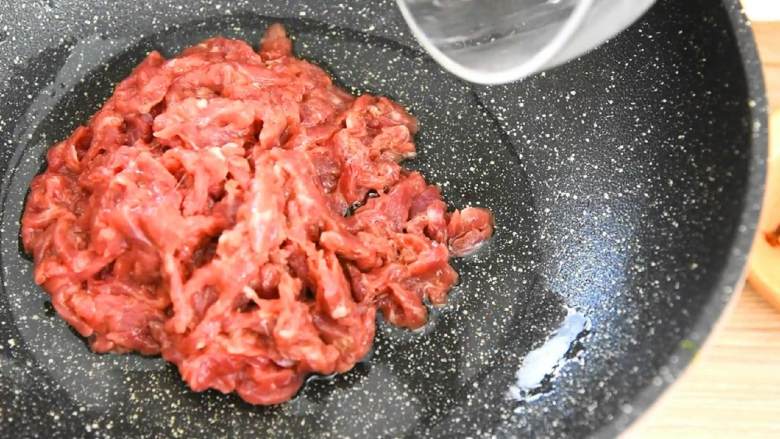 芹菜牛肉,锅里倒入两大勺油,滑散牛肉丝,炒至变色。