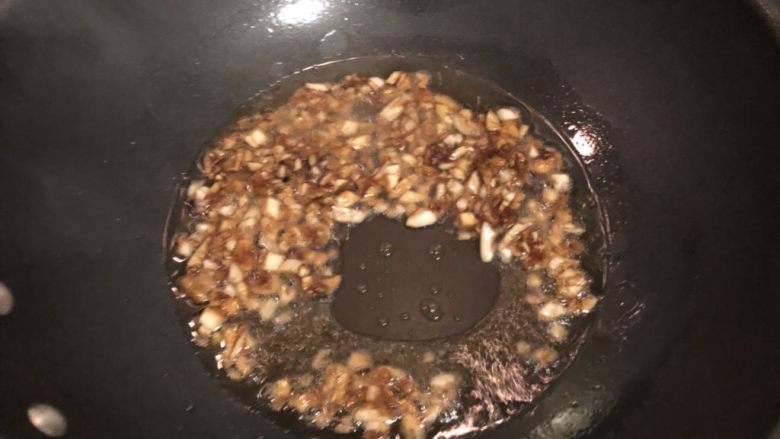 蒜香鸡翅,油锅里余下一些油,将蒜末放入翻炒至变色。