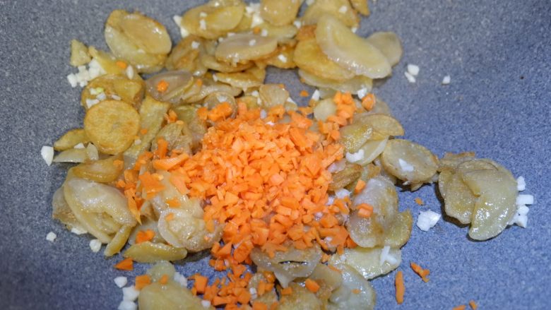 孜然土豆干,在加入胡萝卜碎,翻炒均匀