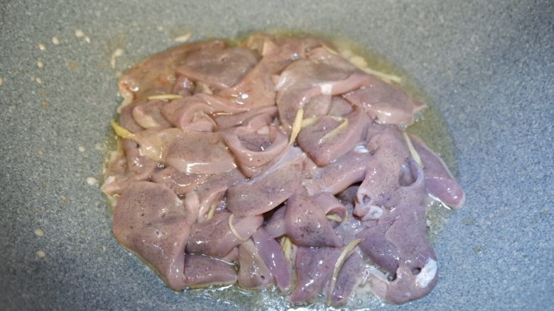 韭菜炒猪肝,锅中热油,下猪肝,连着腌料一起放入,快速煸炒几下