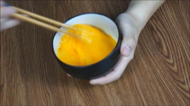豆腐白似银,鸡蛋黄如金——金银豆腐,<a style='color:red;display:inline-block;' href='/shicai/ 9'>鸡蛋</a>打入碗中,加入食盐搅拌均匀。