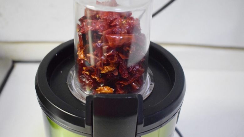 香而不辣的花生油辣椒,炒好的辣椒段放入料理机的绞肉杯中,启动1档,打碎约10秒即可,分批次的打碎辣椒段。