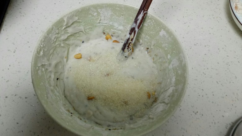 年糕椰蓉小丸子,糯米粉放入碗中，一边搅拌一边适量多次加入开水，喜欢吃软的多放点水，喜欢吃硬的少放点水，一般水和面的比例1:2，加入花生、白糖、芝麻搅拌均匀。