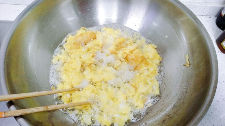 孩子最爱~泡蛋番茄汁,关火之后,用筷子迅速的搅拌鸡蛋,搅拌成一块块的,然后用筷子把鸡蛋夹起来,因为油比较多,不要直接用铲子盛鸡蛋。